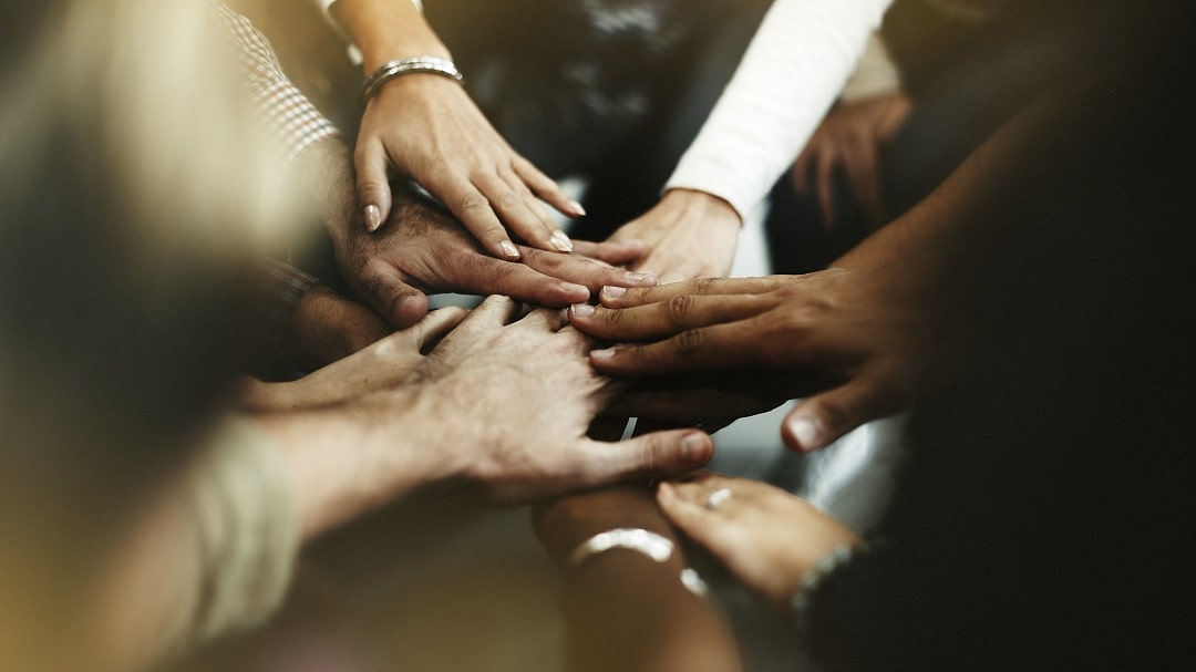 closeup-diverse-people-joining-their-hands-min